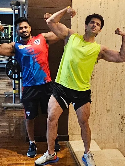 Double biceps pose. Having a training partner can make workouts more enjoyable and push you to lift heavier and work harder.