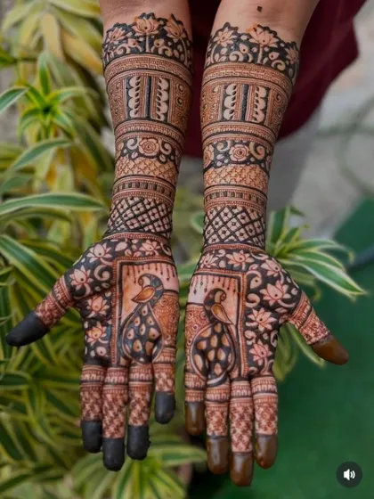 This design features bold, dark shading that makes the peacock figures and floral patterns pop. The solid-colored fingertips are a classic bridal choice.