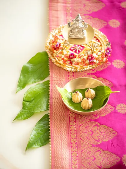An alternate angle of the Ganesh Chaturthi setup, showing the arrangement of betel leaves and modaks. This provides a different perspective on the detailed styling.