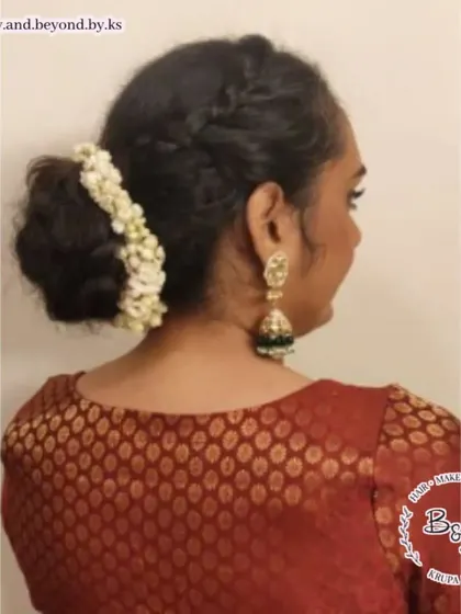 This hairstyle combines two beautiful elements: a textured messy bun and crown braids. Adorned with a simple gajra, this look is perfect for anyone with curly hair wanting a secure yet stylish updo for a wedding.