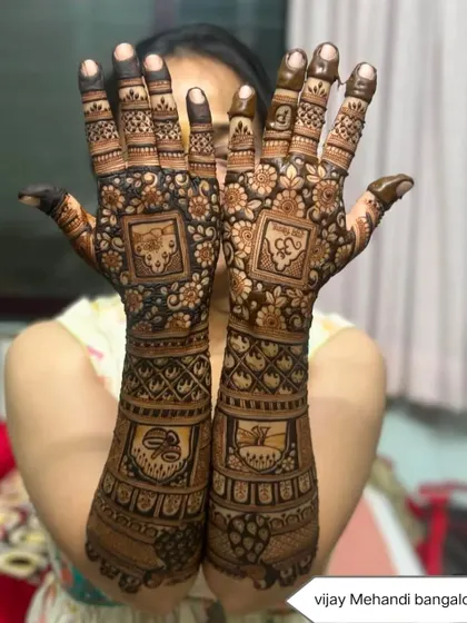 A proud client showing off her full bridal mehndi, which includes religious symbols and personalized initials. I can incorporate any special element you want into your design.