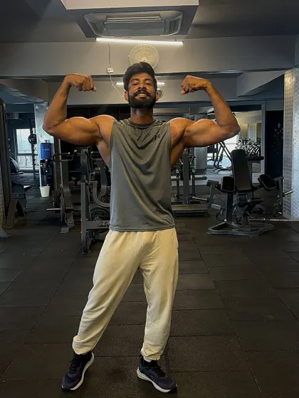 Pointing to the peaks. This pose highlights the bicep development that comes from focused and intense curling movements.