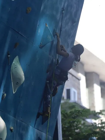 A competitor navigates a challenging route on the impressive Yavanika climbing wall during the national competition.