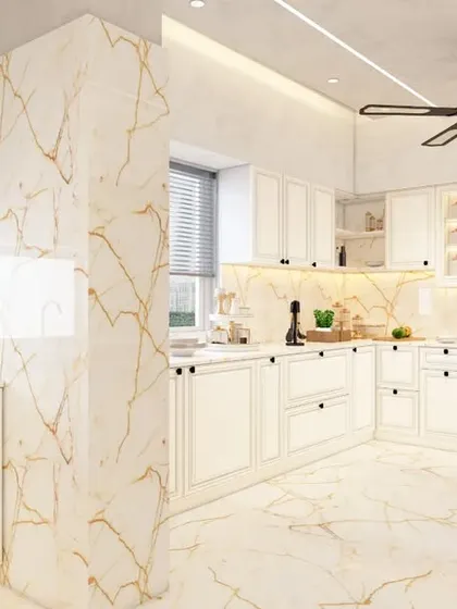 The L-shaped kitchen with white cabinets and gold-veined marble-look tiles, creating a bright and luxurious cooking space.