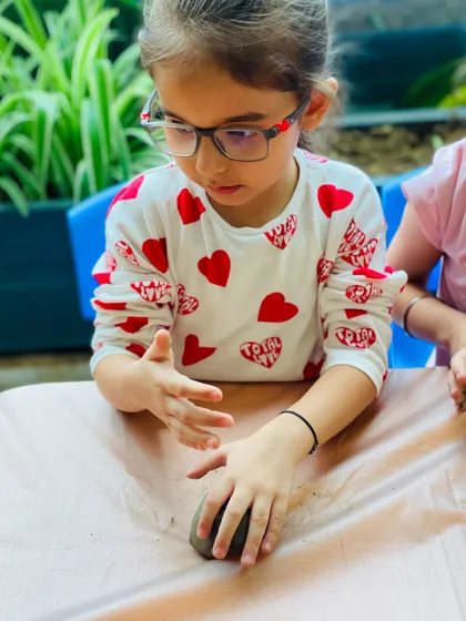 Every detail matters! This participant is smoothing the surface of her clay Ganesha, learning about texture and form in a fun, hands-on way.