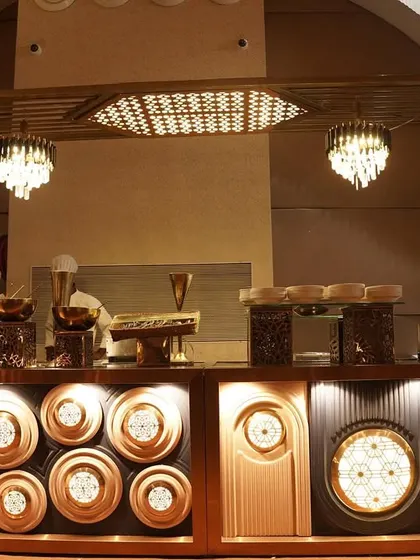 For a more contemporary feel, I created this Art Deco inspired buffet design. The setup features geometric patterns, warm backlighting, and crystal chandeliers, providing a sophisticated and glamorous backdrop for the culinary spread.