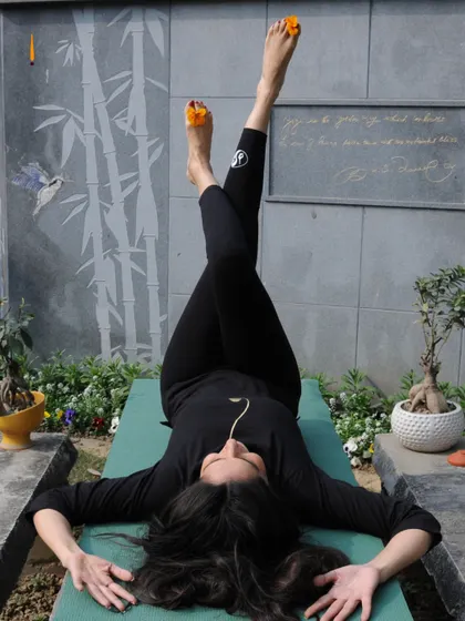 A moment of stillness and strength. A student practices a restorative pose in our beautiful garden, connecting with the earth beneath and the sky above.