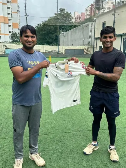 A player receives his team jersey from the coach. This signifies the trust and responsibility placed on him for the upcoming tournament.