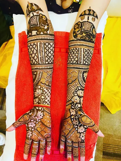 Another view of the stunning bridal mehndi with elephant motifs. This photo shows the bride happily displaying her intricate henna art.