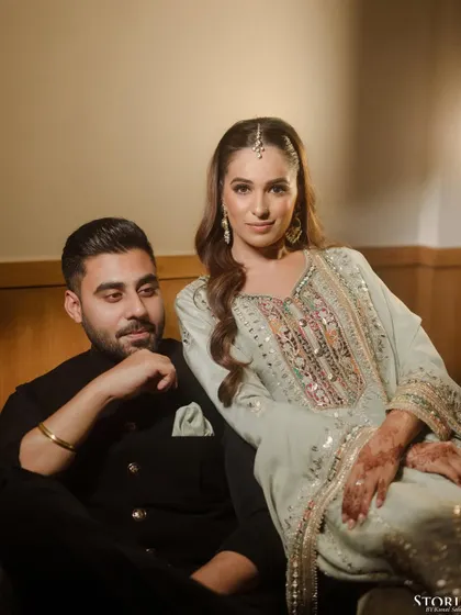 A regal and poised portrait of a couple during their Roka ceremony. The lighting and composition give it a formal, almost painterly quality.