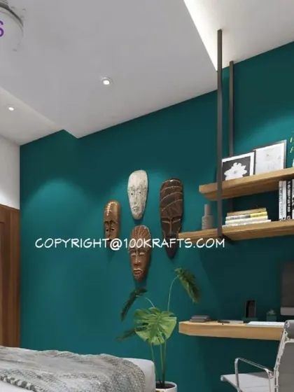 This bedroom features a deep teal accent wall adorned with ethnic masks, creating a unique and culturally rich focal point. The floating desk and shelves provide a functional workspace.