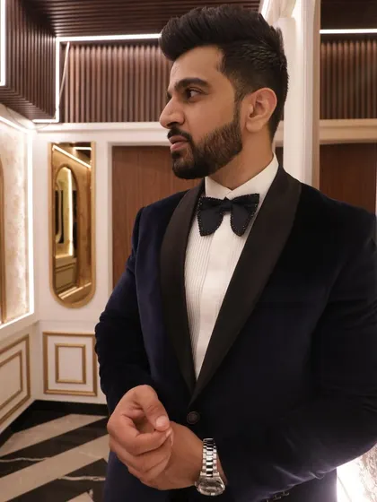 For the brother of the bride, a look that is both suave and significant. This bespoke velvet tuxedo in a deep midnight blue features a classic shawl collar and is paired with a formal bow tie. It's a statement of understated luxury for a very special occasion.