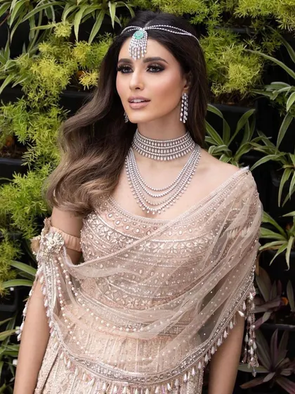 A modern, chic reception look with soft waves and diamond jewelry. The makeup is clean and luminous, focusing on enhancing the model's features for a sophisticated evening style.
