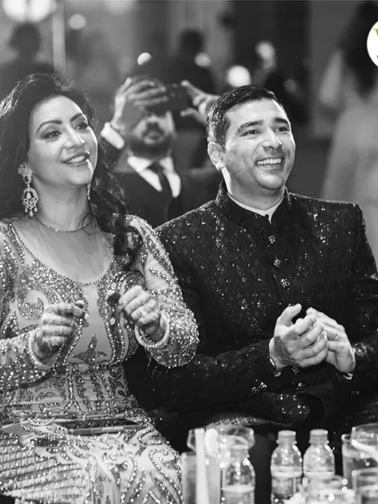 Capturing the joy of the family is just as important as the couple's moments. Here, the parents of the groom enjoy the Sangeet performances, a testament to a well-planned, stress-free event.