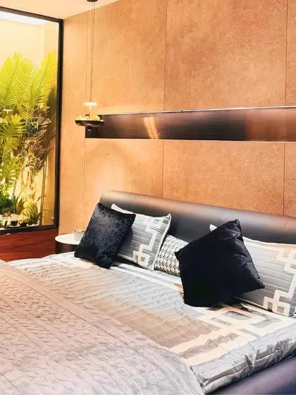 A detailed view of the bed and headboard, showcasing the rich textures and dark color palette that create a cozy and intimate atmosphere in this modern bedroom.
