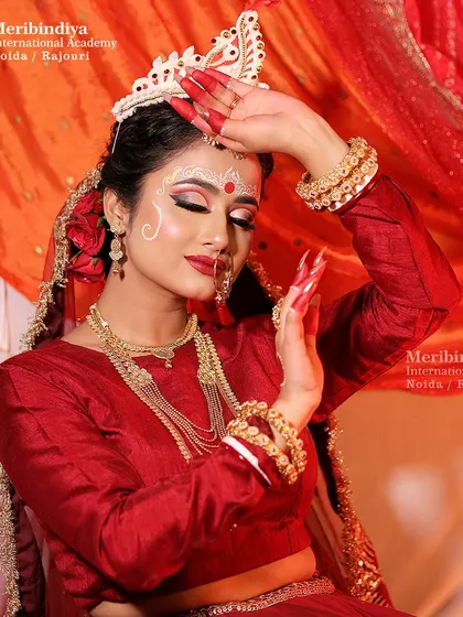The elegance of a Bengali bride in a graceful pose, with her hair neatly tied in a bun to support the traditional headpiece.
