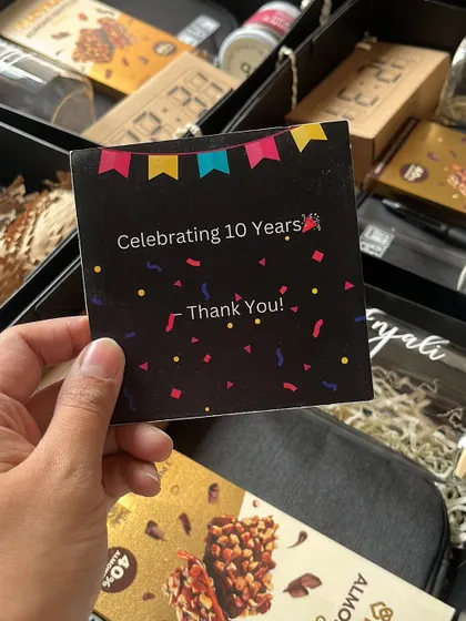 A close-up of the custom "Celebrating 10 Years" thank you card included in the Bloomberg anniversary hampers, adding a personal and celebratory touch.