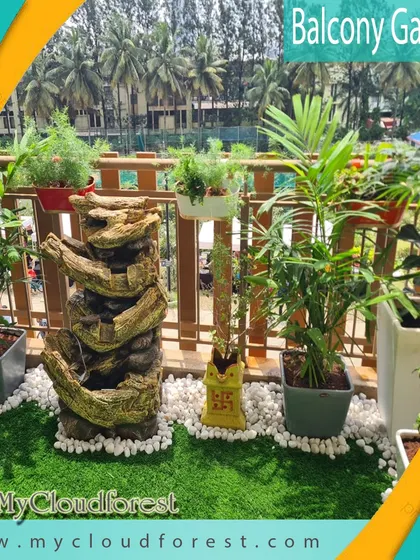 This balcony features a unique, rustic tree-trunk-style water fountain that adds character and the soothing sound of water. Surrounded by potted plants on a bed of white pebbles and artificial grass, it’s a vibrant and lively space with a touch of nature's artistry.