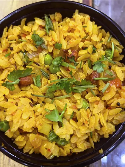 A bowl of my vegetable Poha, garnished with fresh coriander. It's a light, healthy, and popular breakfast choice.