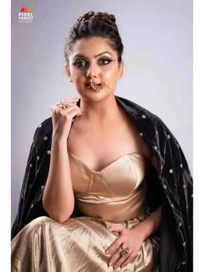 A modern take on traditional elements. This look combines a golden satin outfit with a contemporary graphic eye and a fusion nose accessory for a unique portfolio shot.