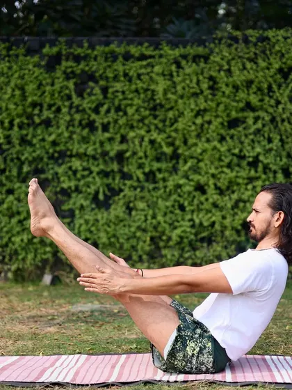 Holding Navasana (Boat Pose) requires immense core strength and stability. This fundamental posture from the primary series is excellent for strengthening the abdominal muscles and improving digestion. Here, I am practicing outdoors, connecting the energy of the earth with the fire of the practice.