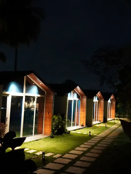 The cozy cabins at our Nandi Hills resort lit up at night. The warm lighting creates a magical and inviting atmosphere for our guests.