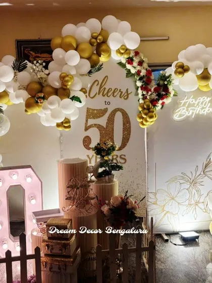 Another angle of the 'Cheers to 50 Years' party decor, showing the full balloon arrangement and prop setup.
