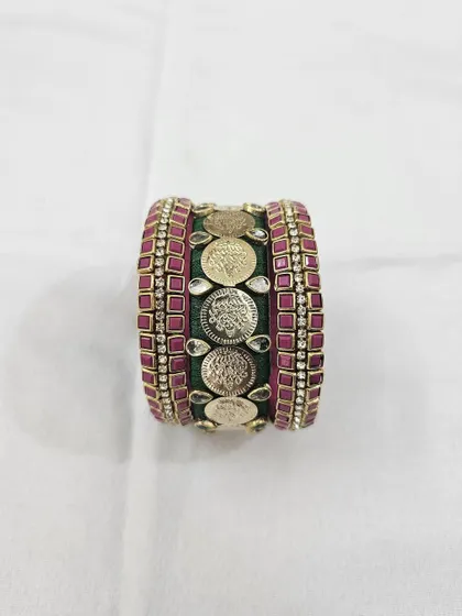 The green and pink temple coin bangle set, viewed from the front to show the complete stacked design.