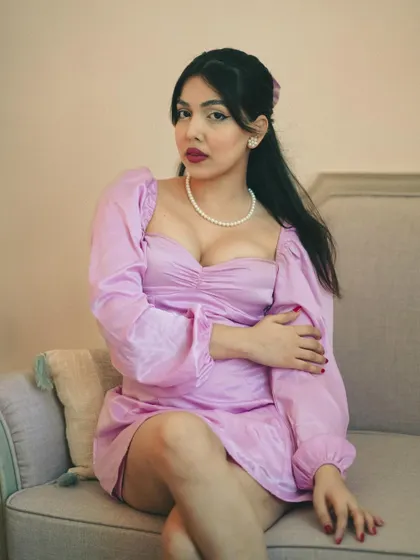 A classic portrait with a vintage feel. The pearl necklace, the dress style, and the soft lighting all come together to create a timeless, elegant look.