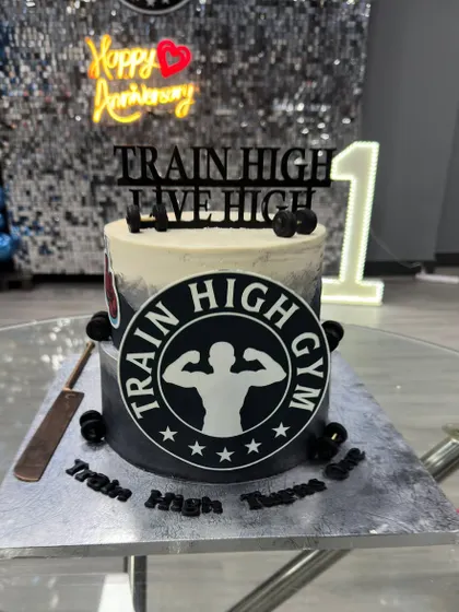 Train hard, treat harder! A custom cake designed for the first anniversary of a gym, featuring their logo and a fitness theme.
