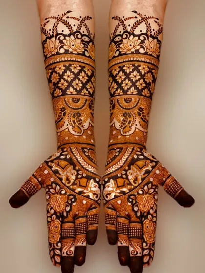 A stunning example of negative space design, where bold elephant and floral motifs are highlighted against a dark henna background.