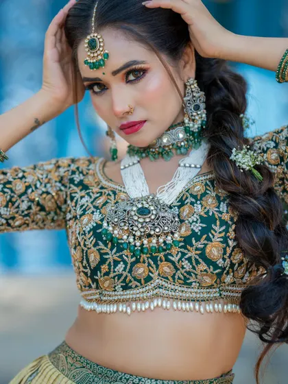A powerful and confident pose from the bride. This shot highlights the detailed craftsmanship of her jewelry and the flawless makeup application.