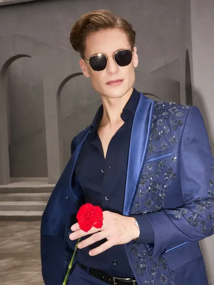 Confidence tailored for the modern gentleman. This shot captures the attitude of the embellished navy suit, a piece designed not just for an event, but for creating a memory. The satin lapel adds a final touch of luxury.