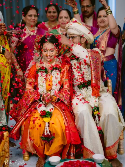 A shower of red petals during the wedding ceremony, a moment of pure joy and celebration.