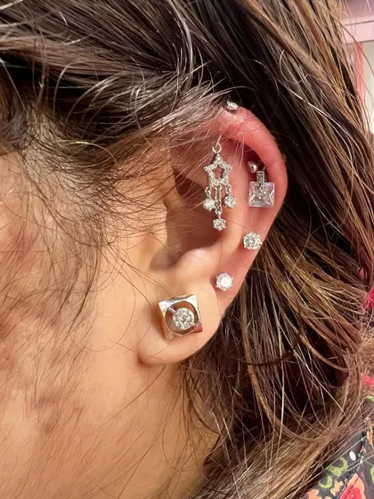 A sophisticated and modern ear stack with a hanging star chandelier and square solitaire studs.