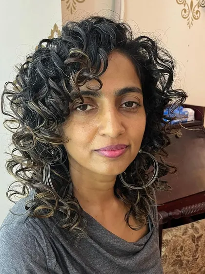 A curly haircut for Kritika, designed to add volume and definition to her texture.