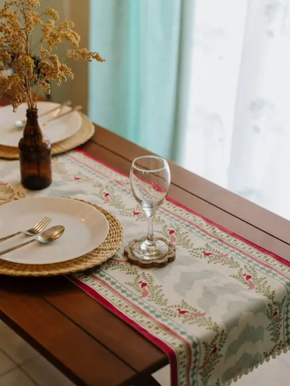 A wider view of the festive table setting with our Rani Collection runner. The vibrant pinks and greens of the fabric add a celebratory feel, perfect for hosting a Diwali dinner.