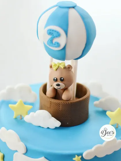 The teddy bear in the hot air balloon topper is a sweet focal point for this birthday cake.