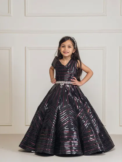 A confident pose in the black taping gown, showing off the structured bodice and sparkling belt.