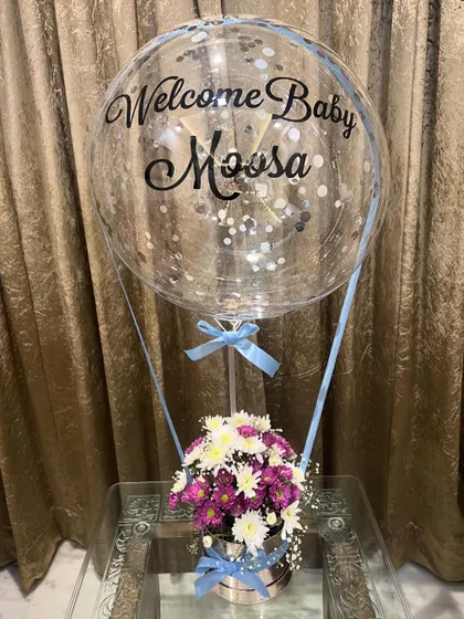 A full view of the baby boy hot air balloon gift. The combination of fresh flowers in the silver box and the floating personalized balloon makes for a perfect congratulations gift.