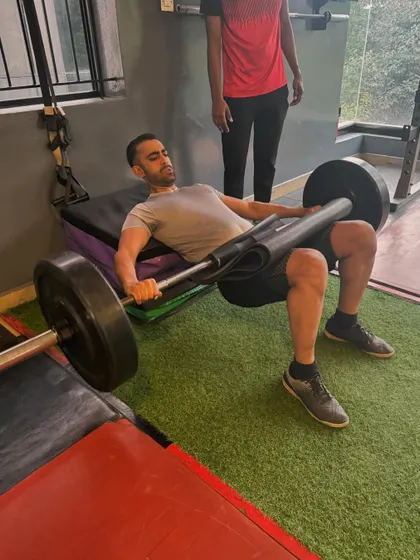 A client executes a heavy barbell hip thrust, one of the most effective exercises for building powerful glutes, which are critical for lower back health and athletic power.