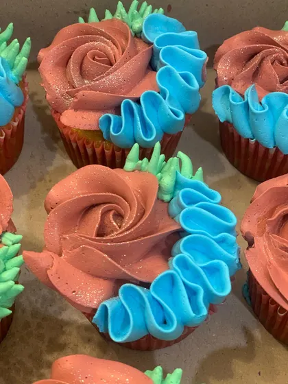 A close-up look at my detailed piping work. These cupcakes feature a combination of a dusty rose buttercream rosette and a bright blue ruffled ribbon design, creating a beautiful contrast in color and texture.