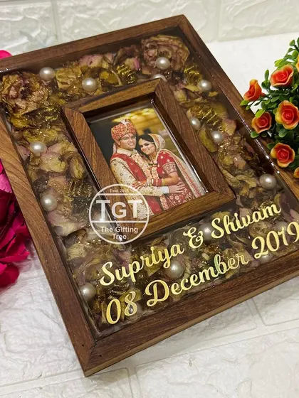 A closer look at the floral teakwood frame, showing how the preserved petals and pearls surround the inset photo.