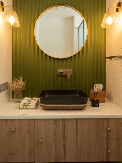 For "Project Ivy," I designed this vanity with an olive green reeded accent wall and a light wood cabinet. The round mirror and warm sconce lighting create a balanced and earthy feel.