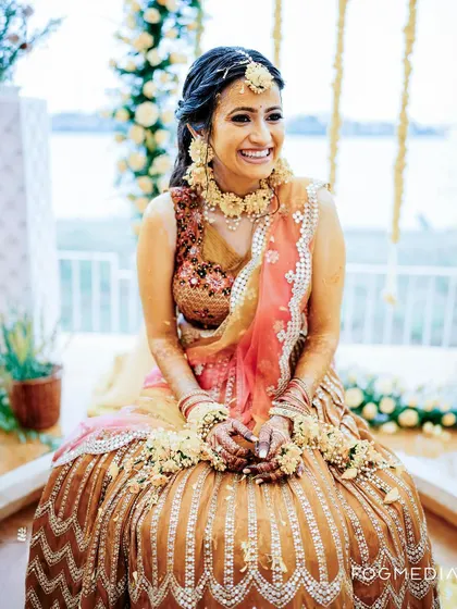 The bride's radiant smile is the centerpiece of this photo from her beautiful Haldi ceremony.