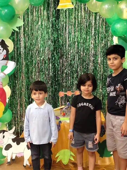 Three young boys pose together at our Janmashtami celebration, enjoying the festive environment we create for every occasion.