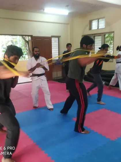 Students practicing their punches with resistance bands, a drill that improves power and speed.