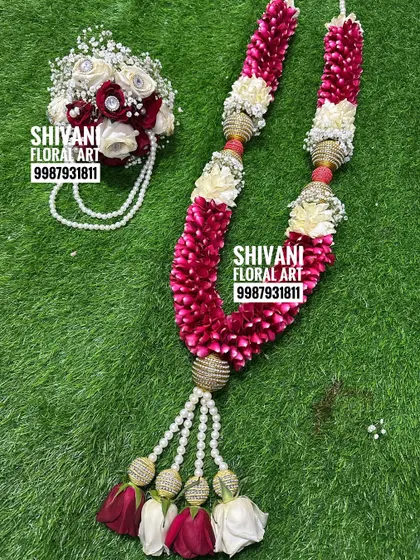 This wedding set includes a beautiful varmala made from red rose petals and white flowers, accented with golden beads. It comes with a matching hand bouquet for the groom, creating a perfectly coordinated look.