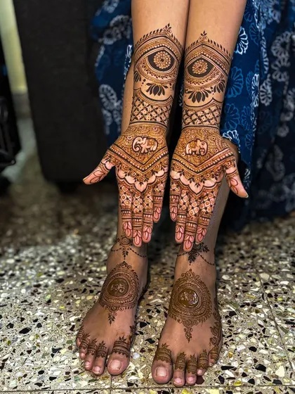 A stunning photo of actress Nayana Nagaraj's bridal mehendi, featuring elegant designs on both her hands and feet.