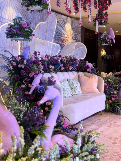 A whimsical transformation of an indoor banquet space, with sculptural swans and hanging birdcages filled with flowers.